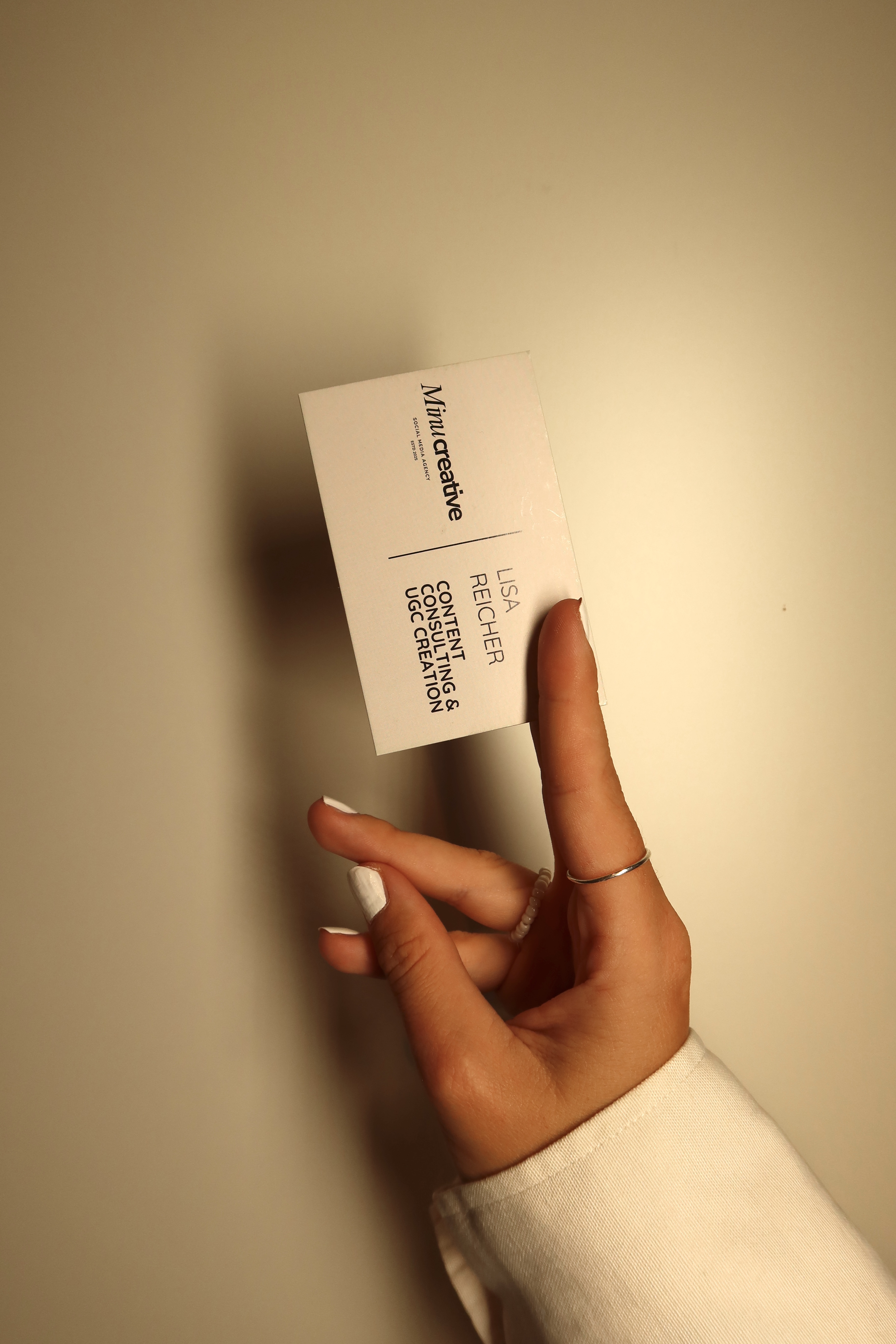 Minu Creative business card held in hand