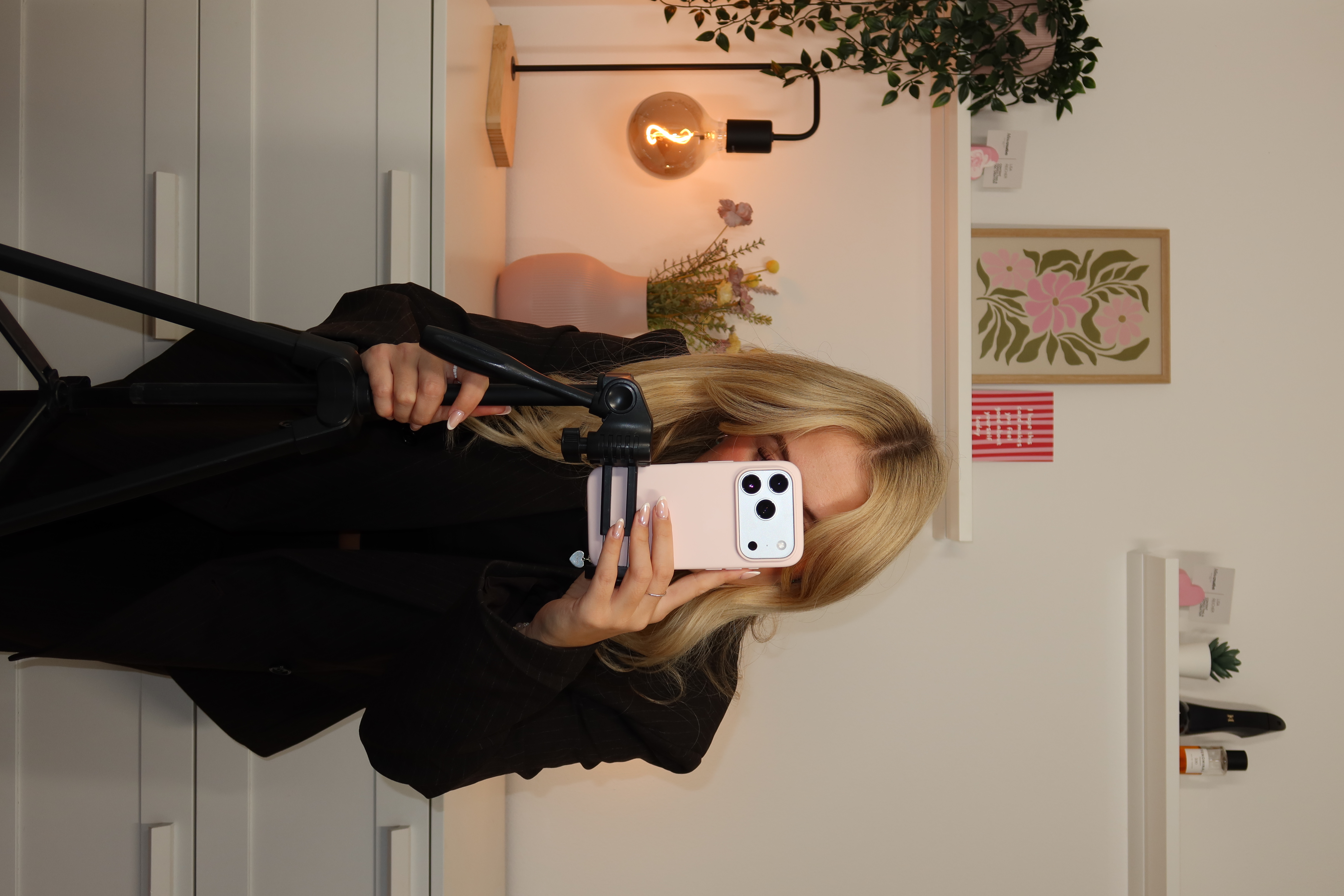 Lisa filming content with a phone on a tripod